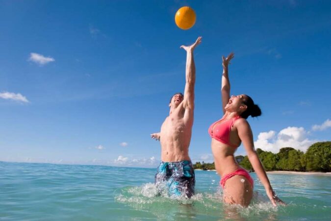 Un couple s'amuse intensément dans l'eau lors d'une partie de jeux de plage dynamiques.